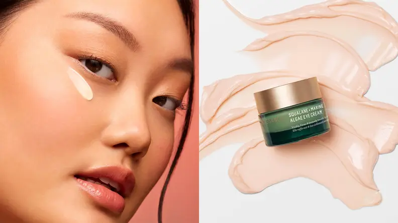 On the left: A person's face with a swatch of eye cream under their eye. On the right: A small green and gold jar on top of a swatch of pink cream.
