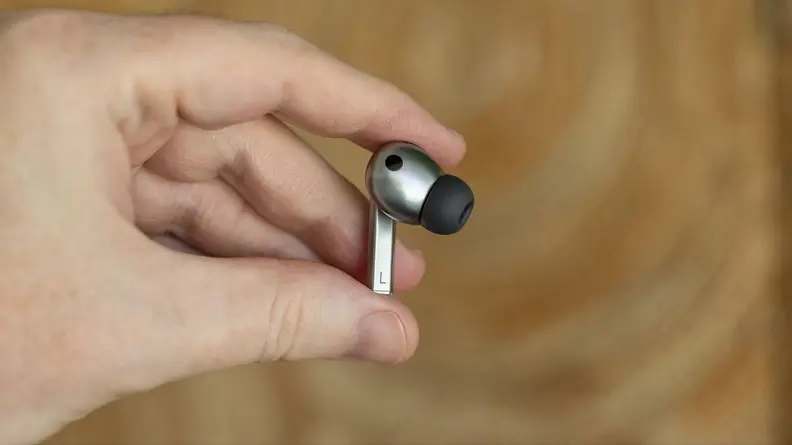 A person holding a single Galaxy Buds3 Pro bud between their fingers.