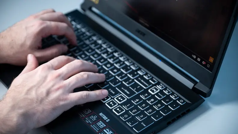 Person types on laptop keyboard