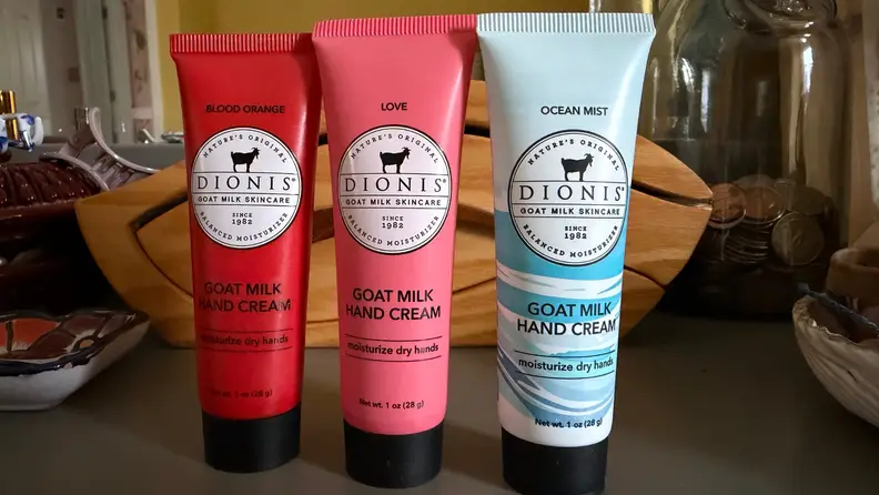 Three containers of handcream stand on a dresser