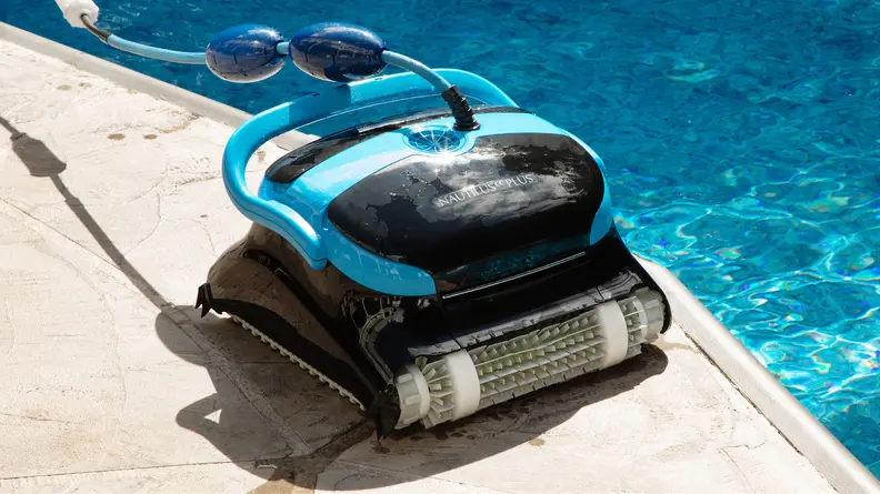 The Dolphin Nautilus CC Plus Wi-Fi sitting next to a swimming pool.