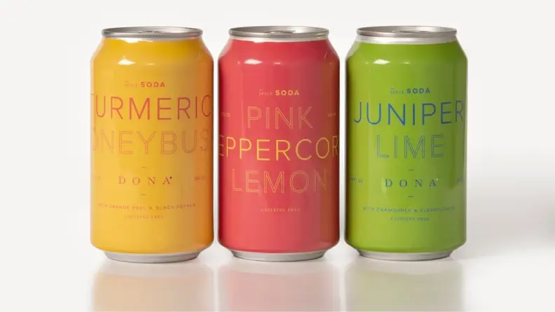 Three colorful cans of spiced soda.