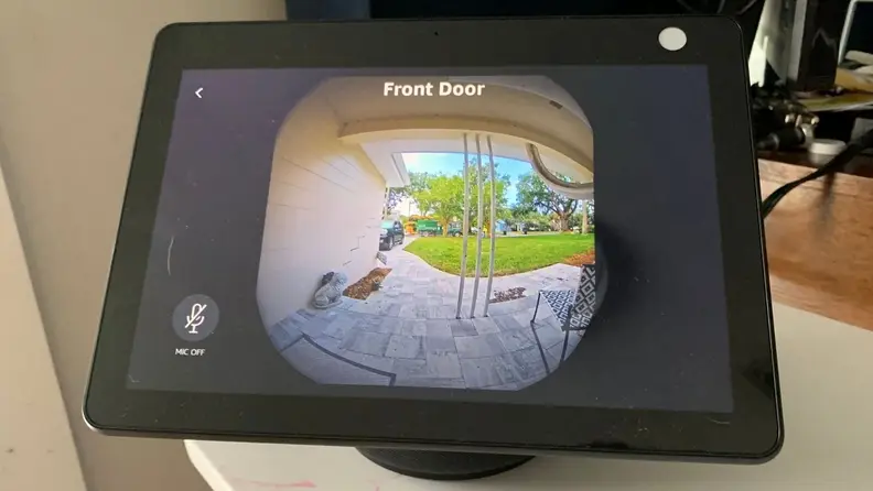 Amazon Echo Show 10 smart display sitting on a white end table.