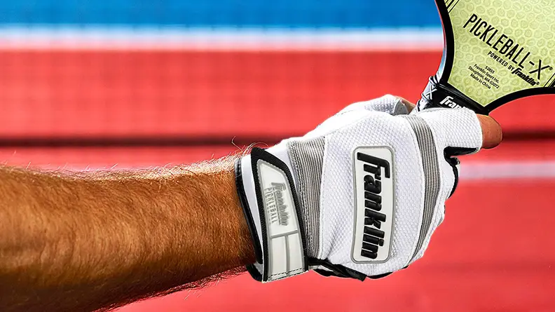 Hand in white glove holding pickleball racket
