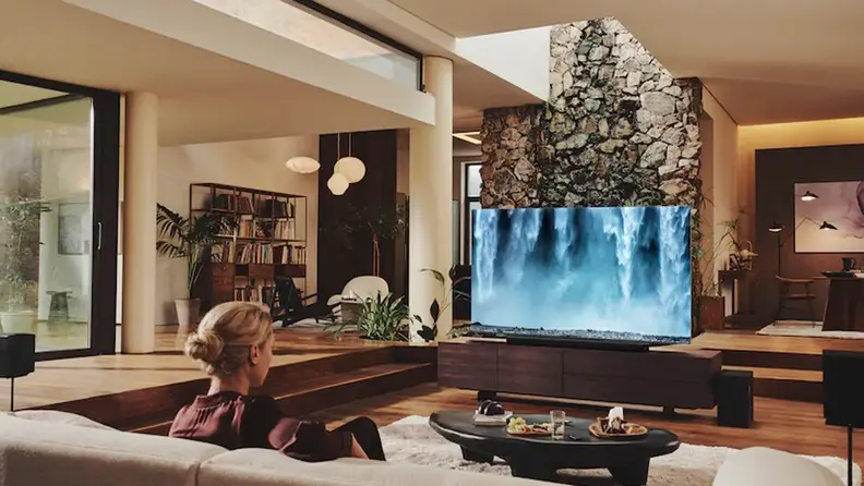 People sit in a living room watching a television.