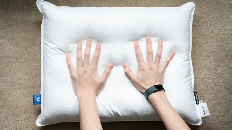 hands pressing down onto a Brooklinen down pillow