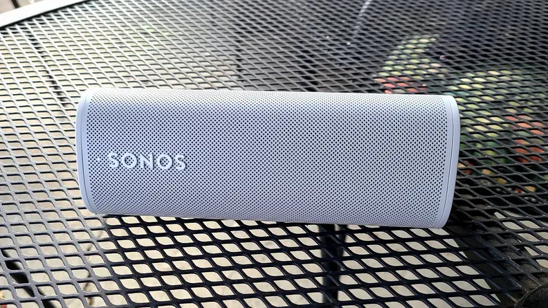 The white and tubular Sonos Roam set on a mesh metal table