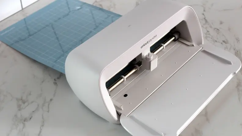 The Cricut Joy Xtra pulled away from the wall so a mat can pass through.