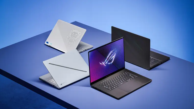 Four iterations of the Asus ROG Zephyrus G14 and G16 in white and black arrayed in a radial pattern on a sleek desk.