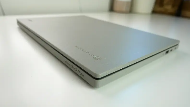 A light gray laptop, closed, on top of a white desk