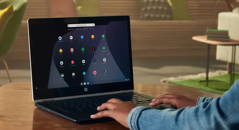 A person typing on a chromebook, resetting the laptop to stock factory settings