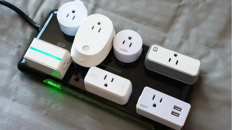 A series of smart plugs plugged into a power strip.