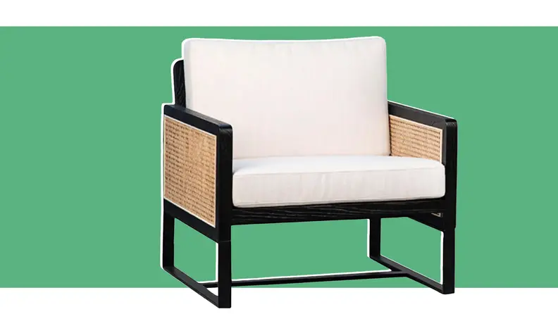 An armchair in front of a green background.