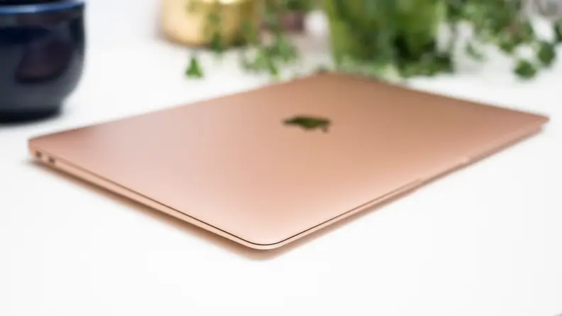 Close-up: a rose-gold MacBook Air, largely out of focus.