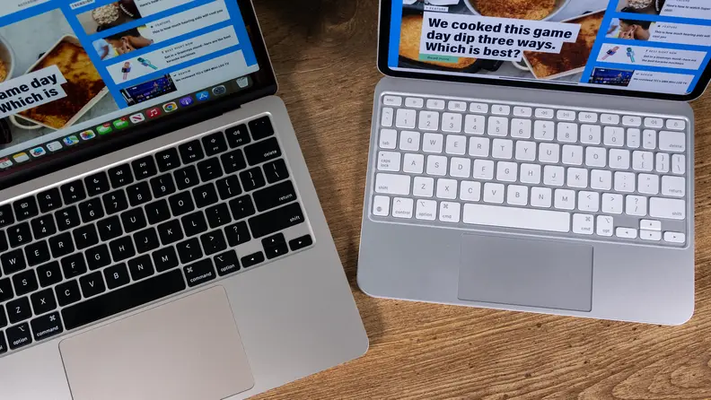 A MacBook Air and an iPad Pro sit on a desk and show off their keyboards