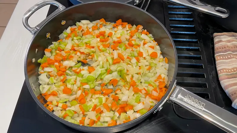 Chopped vegetables being cooked inside a Joesph Joseph pan.