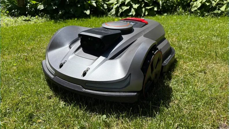 Silver Sunseeker Elite X7 robot lawn mower on top of green grass.