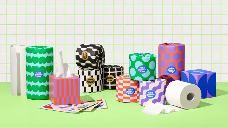 colorful toilet paper rolls and paper towels on green tile
