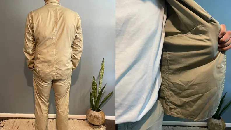 man with back turned to camera show off wrinkled suit by Buck Mason, opened Buck Mason Carry-On Jacket with wrinkles