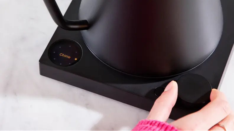 A hand pushing onto the push-dial setting on the Fellow Stagg EKG Pro.