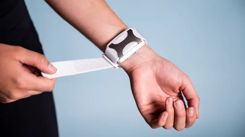 A person adjusts the Apollo Neuro strap on their wrist.
