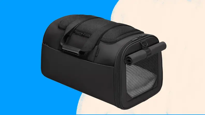 Empty black pet carrier with fur bedding inside.