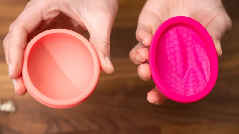 Hands holding nixit menstrual disc and intimina ziggy mesnstrual disc.