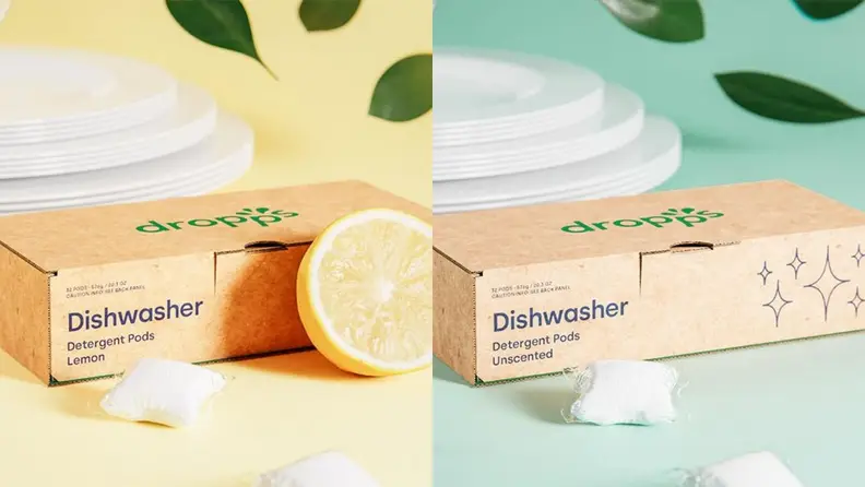 Left: A cardboard box of dishwasher detergent pods in a lemon scent, surrounded by a fresh lemon and a stack of clean white plates. Right: A cardboard box of unscented dishwasher detergent pods surrounded by a stack of clean white plates.