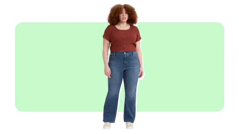 A model wears a pair of blue jeans with a slight bootcut leg and a red T-shirt.