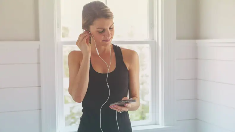 A woman putting in headphones.