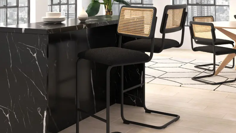 Black bars tools with rattan back in front of a granite counter