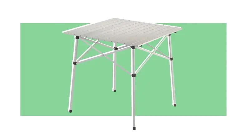 A Coleman portable table on a green background.