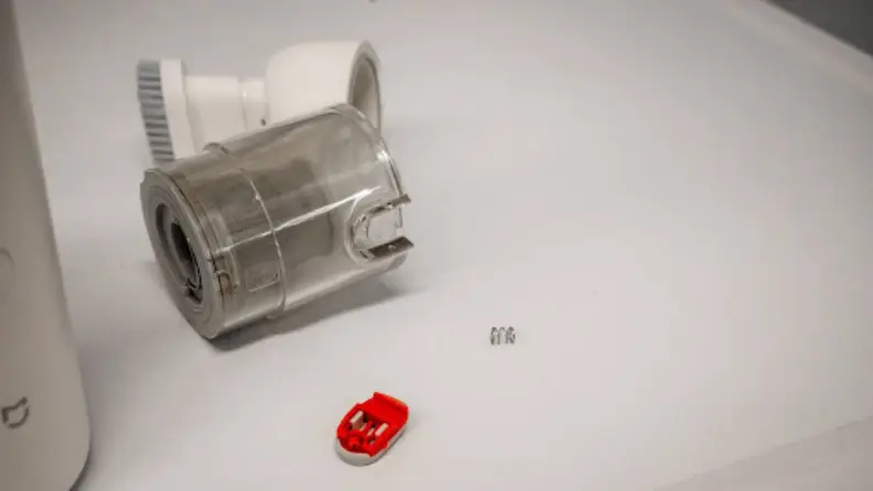 A broken dust cup with its switch and spring detached