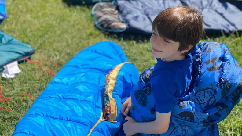 A child smiling in a sleeping bag
