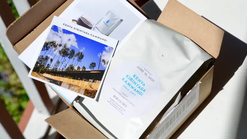 A coffee subscription box opened to reveal a bag of coffee beans.