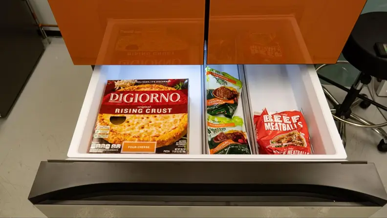 Interior view of the Samsung Bespoke FlexZone drawer with frozen foods inside of the divided compartments.