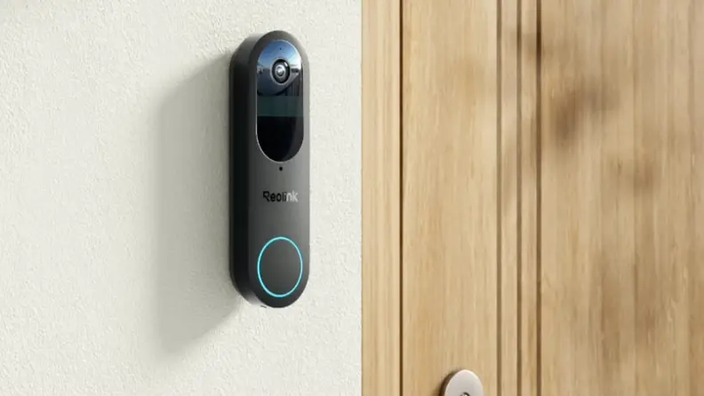 A video doorbell mounted to a wall next to a front door