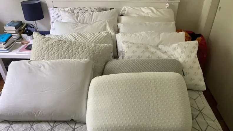 an array of pillows on a bed