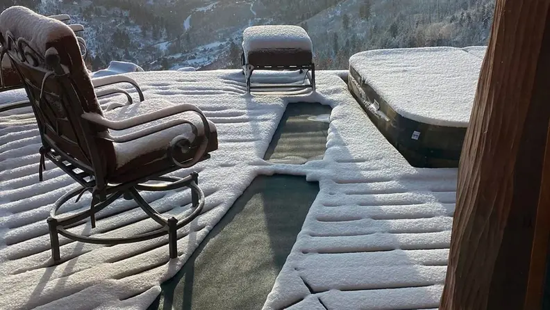 A path is cleared on a deck using heating pads.