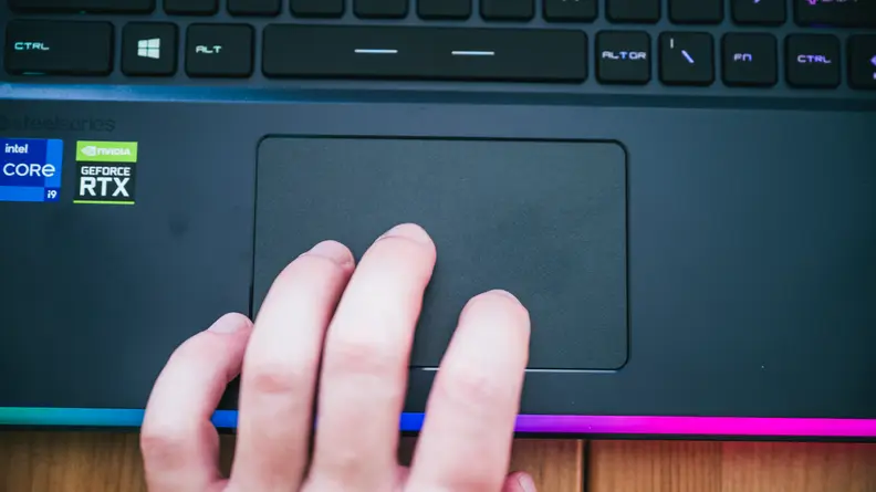 A close up of a hand using the trackpad on a laptop.
