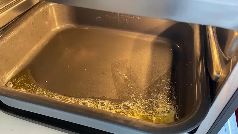 Melted butter inside of the nonstick pan from the Ninja Combi multicooker.