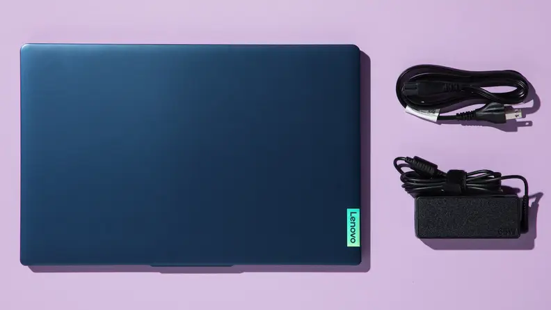 A top-down view of a laptop and its charging accessories.