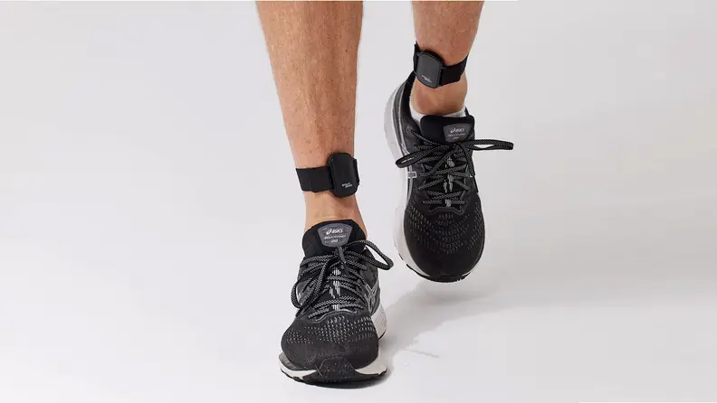 Close up view of the feet and ankles of a person wearing an Evolve Mvmt step tracker on both ankles.