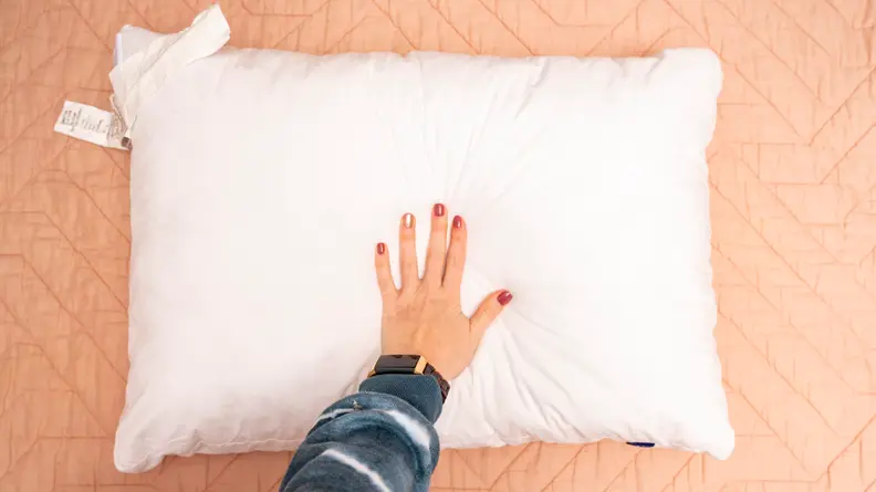 a hand presses into the surface of the Casper Original Pillow