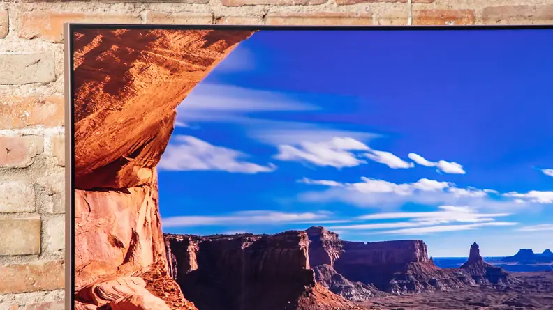 The TV displaying a rocky canyon in a sunny setting.