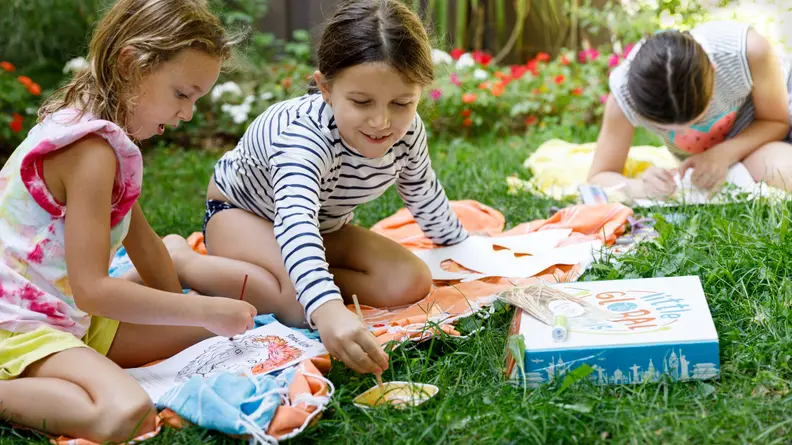 Two girls painting in the backyard
