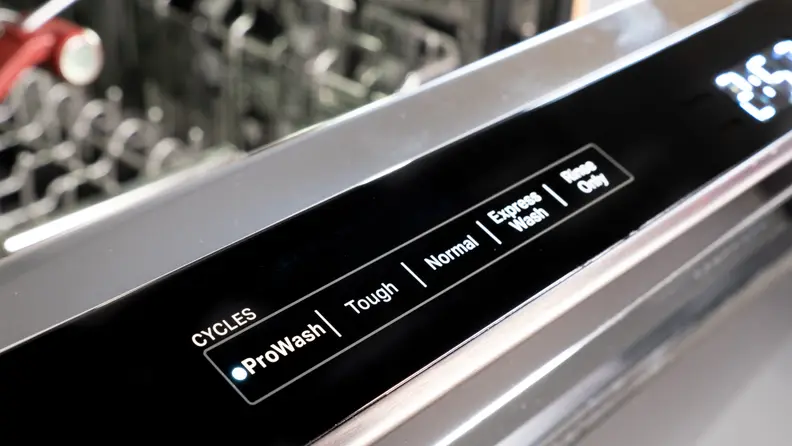 A close up of the KitchenAid KDPM804KBS dishwasher's controls, located along the top edge of its door.