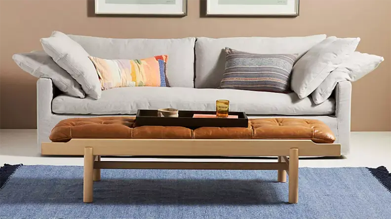 Gray Upcycled Wells Sofa in fount of wooden coffee table and blue rug.