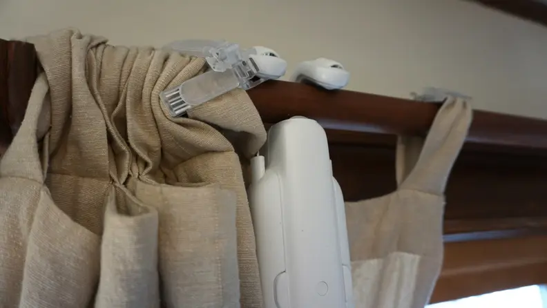 Close-up of the SwitchBot stuck into some curtains.