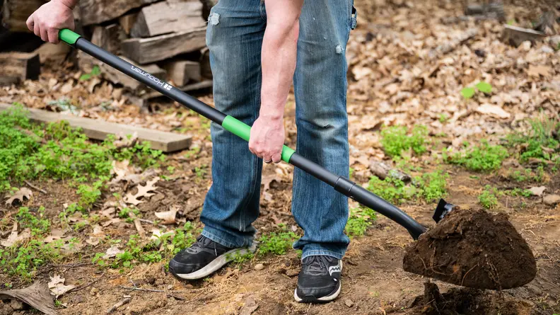 A person scooping dirt outside with the Hooyman Digging Shovel